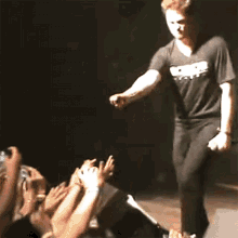 a man wearing a black shirt that says ' nirvana ' on it walks on stage