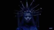 a woman in a blue dress with a crown on her head says vevo