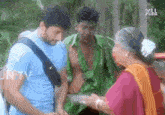 a man in a green shirt is talking to a woman in an orange dress