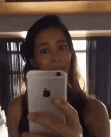 a woman is taking a picture of herself with an apple iphone
