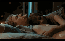 a man and a woman are laying on a bed with fx written on the bottom