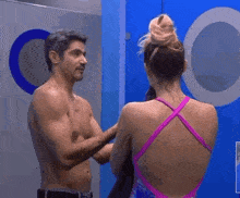 a man and a woman are standing in front of a mirror in a bathroom