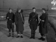 a black and white photo of four soldiers with the pathe logo