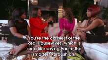 a group of women are sitting on a couch talking to each other and one of them is saying you 're the smartest