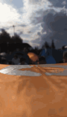 a blurred image of a group of people standing around a large orange object