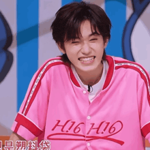 a man wearing a pink shirt that says h16h16