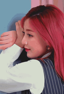 a woman with red hair wearing a white shirt and striped vest