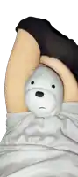 a person is holding a stuffed ice bear between their legs