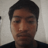 a man with a beard looks at the camera with his eyes closed