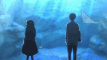 a man and a woman standing in front of an aquarium