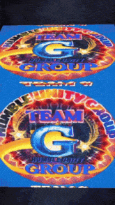 a team g logo is on a blue surface