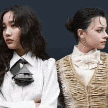 two women standing back to back with their arms crossed and one wearing a tie