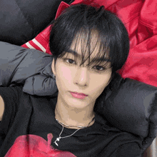 a young man wearing a black shirt with an apple on it is laying on a bed