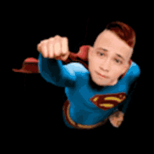 a man dressed as superman is flying through the air