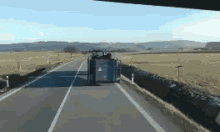 a truck is driving down a highway in a field