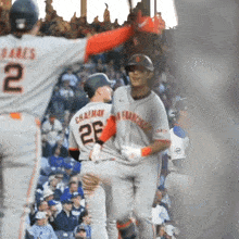 a baseball player with the number 25 on his jersey is being congratulated by another player