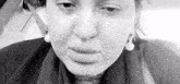 a close up of a woman 's face in a black and white photo while sitting in a car .
