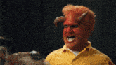 a man with horns painted on his face and a yellow shirt