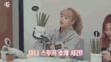a woman holding a potted plant with a sign that says ' twice beauty ' on it