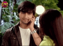 a man talking on a cell phone with a dangal tv logo on the bottom right