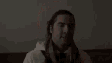 a man with a scarf around his neck is sitting on a couch