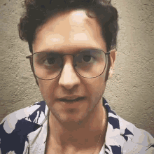 a man wearing glasses and a blue and white shirt