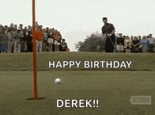 a man is swinging a golf club at a golf ball on a golf course while a crowd watches .