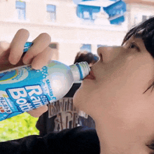a person drinking a bottle of rain bottle water