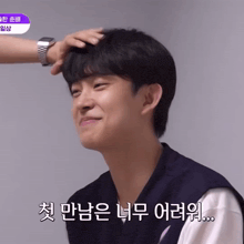 a man 's head is being touched by another man with a watch on