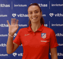 a woman wearing a red shirt that says invictum on it
