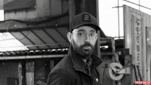 a black and white photo of a man wearing glasses and a hat with the word think jules on the bottom