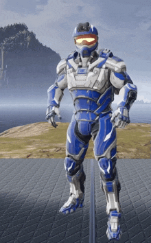 a man in a blue and white armor is standing on a platform