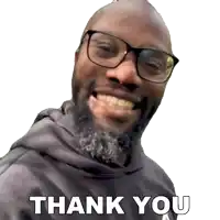 a man with glasses and a beard is smiling and saying thank you