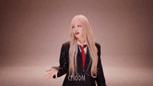 a woman with long blonde hair is wearing a suit and tie and making a funny face .