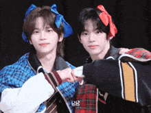 two boys wearing bows on their heads are posing for a picture