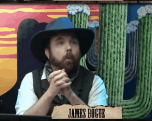 a man in a cowboy hat is sitting in front of a sign that says james bogue