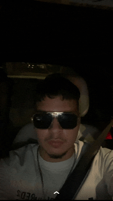 a man wearing sunglasses and a white shirt that says bed on it