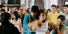 a group of people are standing in a crowd and a man is talking to a woman .
