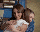 two women hugging each other with one wearing a ring