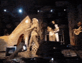 a man playing a guitar and a woman dancing on stage