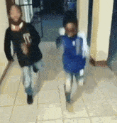 two young boys are running down a hallway . one of the boys is wearing a number 10 jersey .