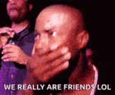 a bald man is covering his mouth with his hand and says `` we really are friends lol ''