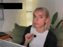 a woman sitting on a couch looking at a laptop screen that says ivor fan