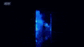 a man in a hat is standing in a dark room with a aew logo behind him .