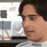 a man wearing a white shirt with the word sparco on the neck