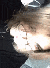 a close up of a person wearing glasses with a black shirt on