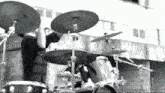 a black and white photo of a drummer playing a set of drums