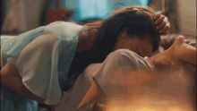 a woman in a blue dress is laying on another woman 's chest