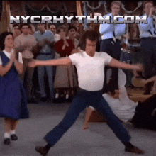 a man is dancing in front of a crowd with nycrhythm.com written in the corner