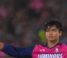 a man in a luminous jersey is holding a bat